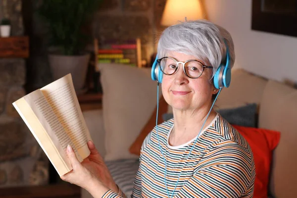 Крупным Планом Портрет Зрелой Женщины Читающей Книгу Слушающей Музыку Наушниками — стоковое фото