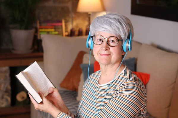 Крупным Планом Портрет Зрелой Женщины Читающей Книгу Слушающей Музыку Наушниками — стоковое фото