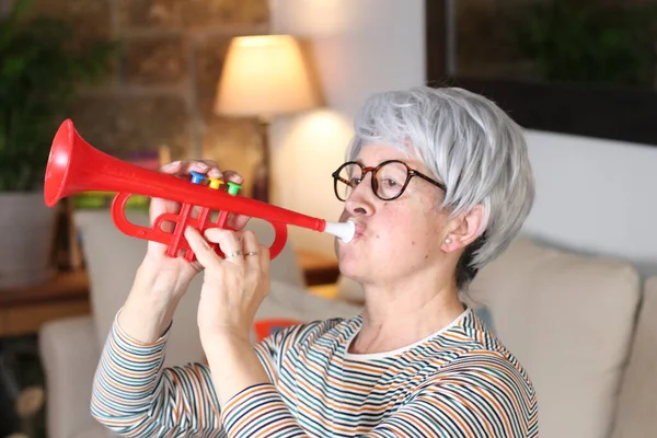 Close Portrait Mature Woman Toy Red Trumpet Sitting Home Quarantine — Stock Photo, Image