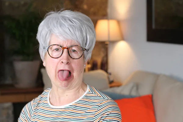 Senior woman sticking tongue out