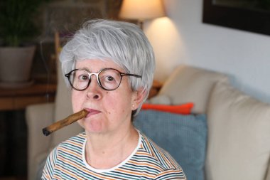 Yaşlı kadın puro içiyor.