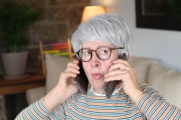 Donna Anziana Stressata Utilizzando Due Telefoni Contemporaneamente — Foto Stock