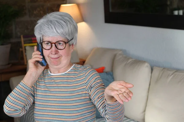 使用固定电话的多管闲事的老年妇女 — 图库照片