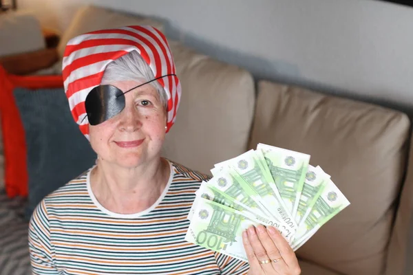 Senior pirate woman holding money