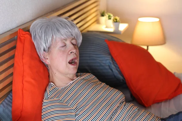 Ώριμη Γκρίζα Μαλλιά Γυναίκα Χασμουριέται Ενώ Χαλαρώνει Στο Κρεβάτι Κατά — Φωτογραφία Αρχείου