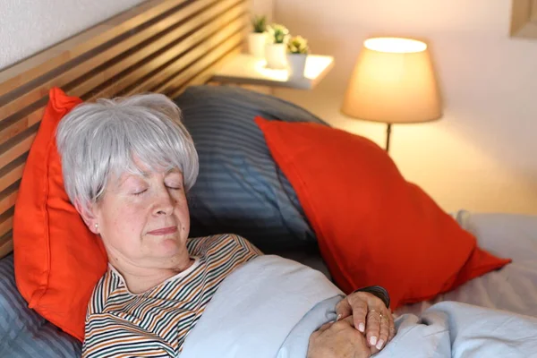 在家里自我隔离时 成熟的灰发女人在床上休息 — 图库照片