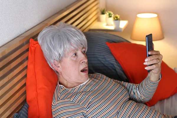 Mulher Cabelos Grisalhos Maduros Usando Smartphone Enquanto Relaxa Cama Durante — Fotografia de Stock