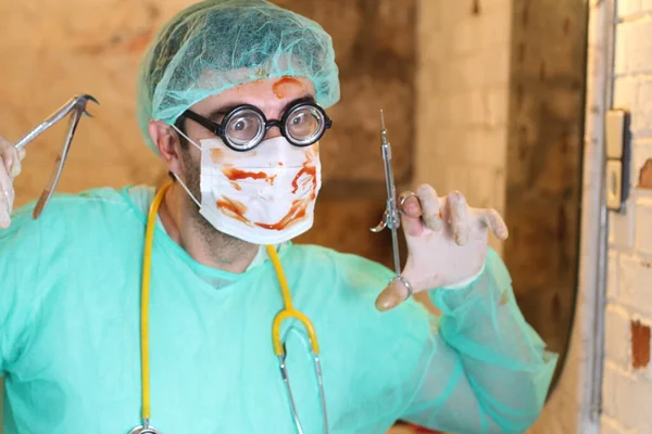 close-up portrait of maniac doctor with dentist tools and blood covered mask