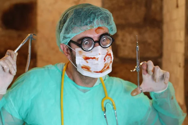 close-up portrait of maniac doctor with dentist tools and blood covered mask