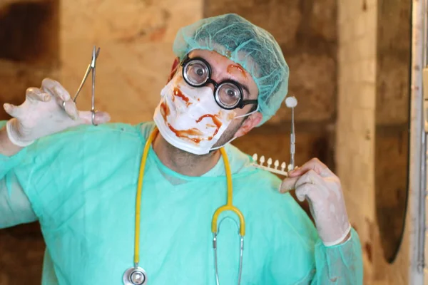 close-up portrait of maniac doctor with dentist tools and blood covered mask