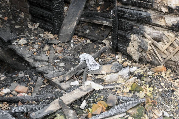 The texture of the destroyed house, charred bricks, rags.