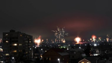 Patlayan havai fişeklerle dolu şehir manzarası.