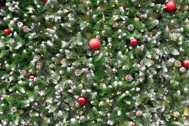 Arka plan şenlikli Noel ve Yeni Yıl desenleri, çalılarla kaplı ladin dalları, Noel topları ve fenerli çelenkler..