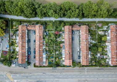 Arabalar için spiral rampalı çatıdaki otoparkın havadan görüntüsü. Yukarıdan sokak ve sanayi bölgesi.