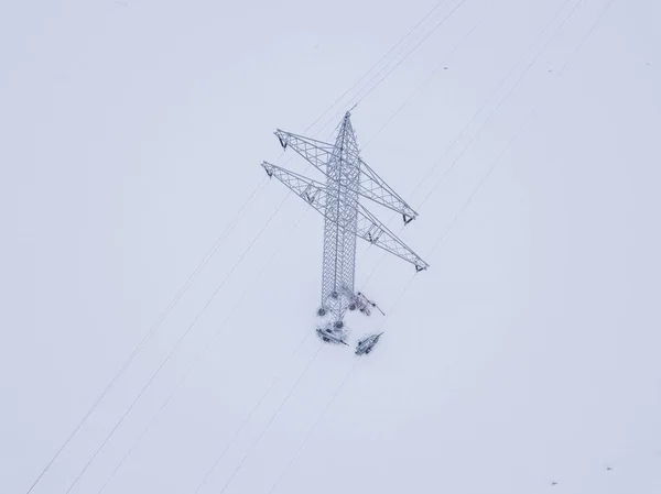 Aerial view of power line in snow covered landscape