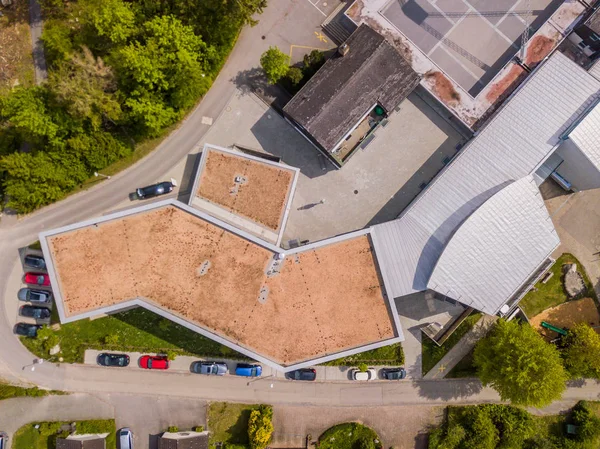 Aerial view of school building in Europe. Roof and cars from above