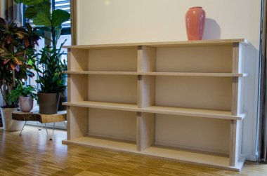 Empty bookshelf made of wood in flat at home clipart