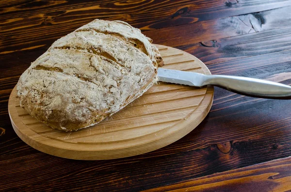 一块木制的桌子上的自制面包 — 图库照片