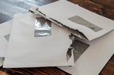 Tahta masanın üzerinde duran bir yığın açık zarf. Mektup Yığını