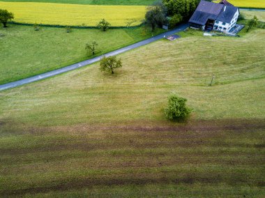 Sonbahar mevsiminde İsviçre dağlarındaki kır evinin havadan görünüşü