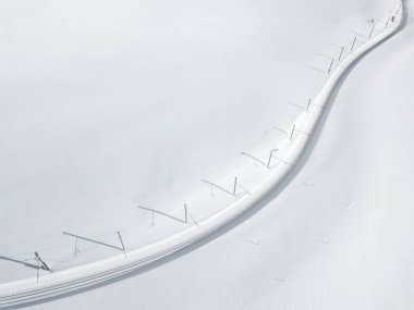 İsviçre 'de karla kaplı arazide demiryolu manzarası