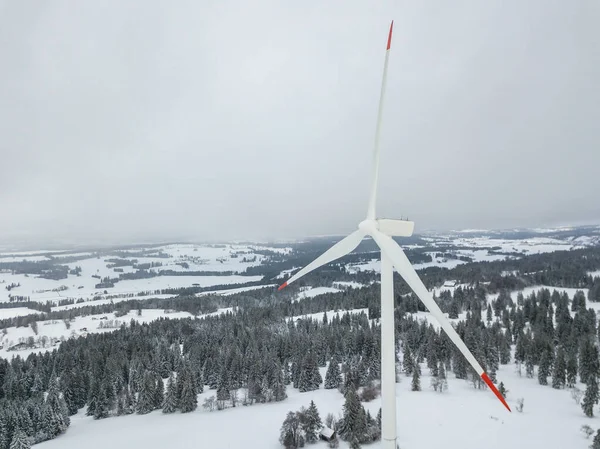 Aerial view of wind turbine in snow covered landscape