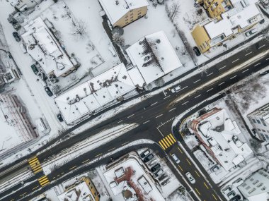 Karla kaplı çatıları olan İsviçre şehrindeki hava manzaralı yol