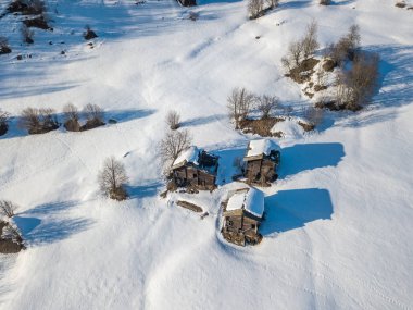 İsviçre'de küçük kırsal kasabada karla kaplı evlerin havadan görünümü