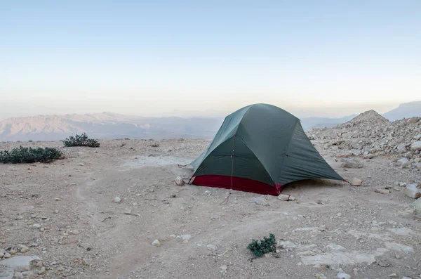 Wild camping in Oman with tiny tent on rocky underground in Oman