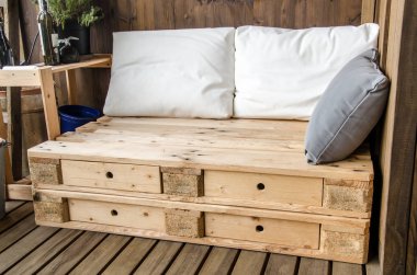 Balkonda rahat ahşap bir kanepe.