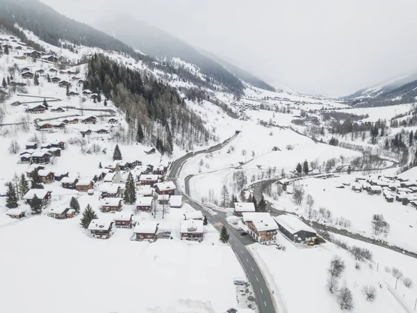 冬の山村の屋根付きの屋根の雪の空中ビュー — ストック写真
