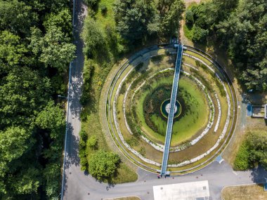 Ağaçlar arasındaki dairesel yuvarlak park yapısının havadan görüntüsü
