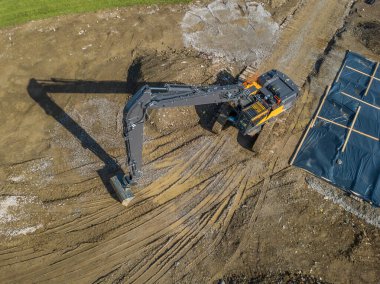 İnşaat alanındaki büyük kazıcının hava görüntüsü.