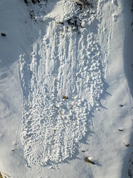 Aerial view of snow avalanche on mountain slope.