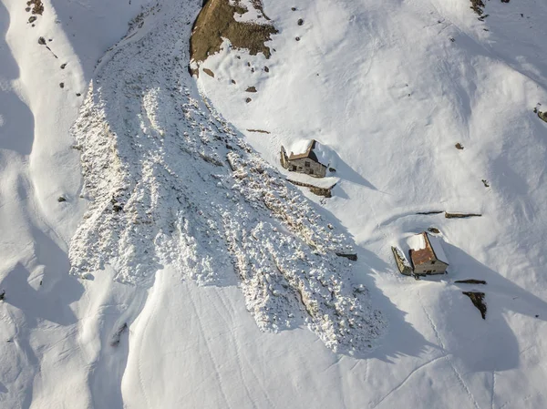 Aerial view of snow avalanche on mountain slope.