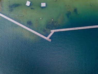 Göl üzerindeki yaya köprüsünün havadan görüntüsü. Dar tahta köprü