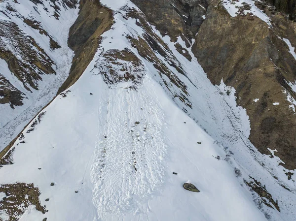 Aerial view of snow avalanche on mountain slope.