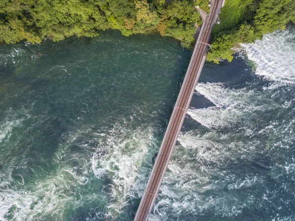 Aerial view of railway bridge with one track across rhine river in Switzerland.