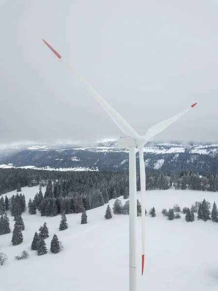 Aerial view of wind turbine in snow covered landscape