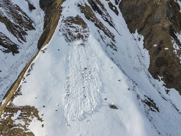 Aerial view of snow avalanche on mountain slope.