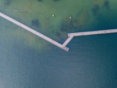 Göl üzerindeki yaya köprüsünün havadan görüntüsü. Dar tahta köprü