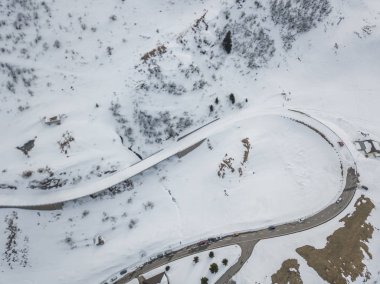 Kış manzarasında kavisli ve karlı yolların havadan görünüşü 