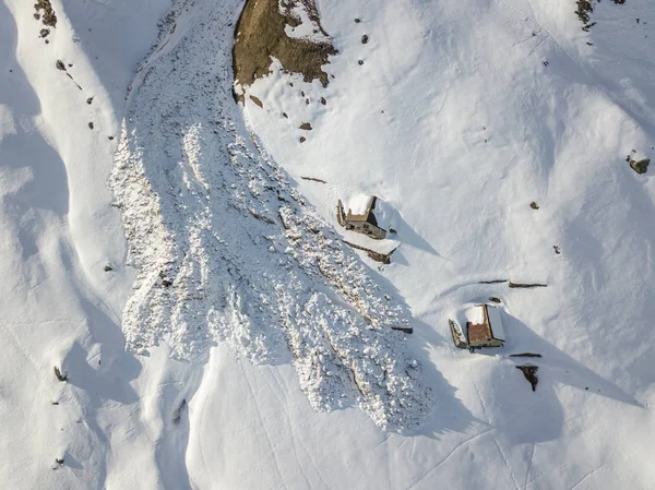 Aerial view of snow avalanche on mountain slope.