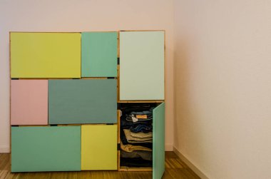 Giysiler için renkli kapıları olan şarap kutularından yapılmış ev yapımı dolap.