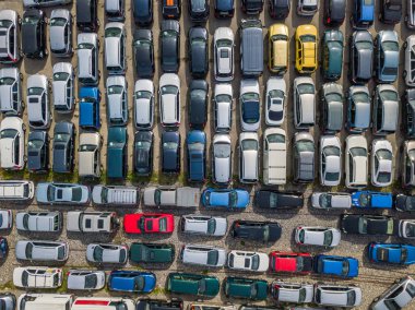 Aerial view of car park with many car standing in chaotic order 