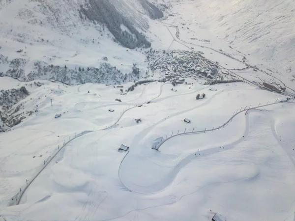 以弧度作为滑雪坡道的白雪覆盖道路的空中景观 — 图库照片