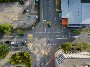 İsviçre 'deki yol kavşağının havadan görüntüsü. Yollar ve arabalar yukarıdan. Caddeden karşıya geçen yayalar..