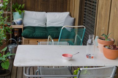 Balkondaki beyaz masada boş bir kase. Rahat bir yaşam tarzı.