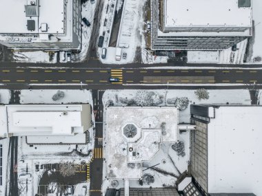 Karla kaplı çatıları olan İsviçre şehrindeki hava manzaralı yol