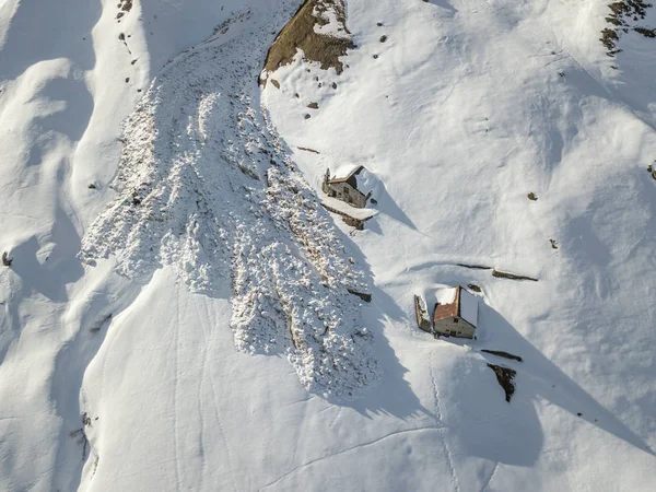 Aerial view of snow avalanche on mountain slope.